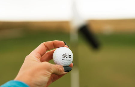 golfer holding golf ball in hand