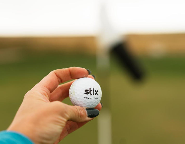 golfer holding golf ball in hand