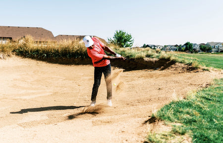 golfer chipping from bunker