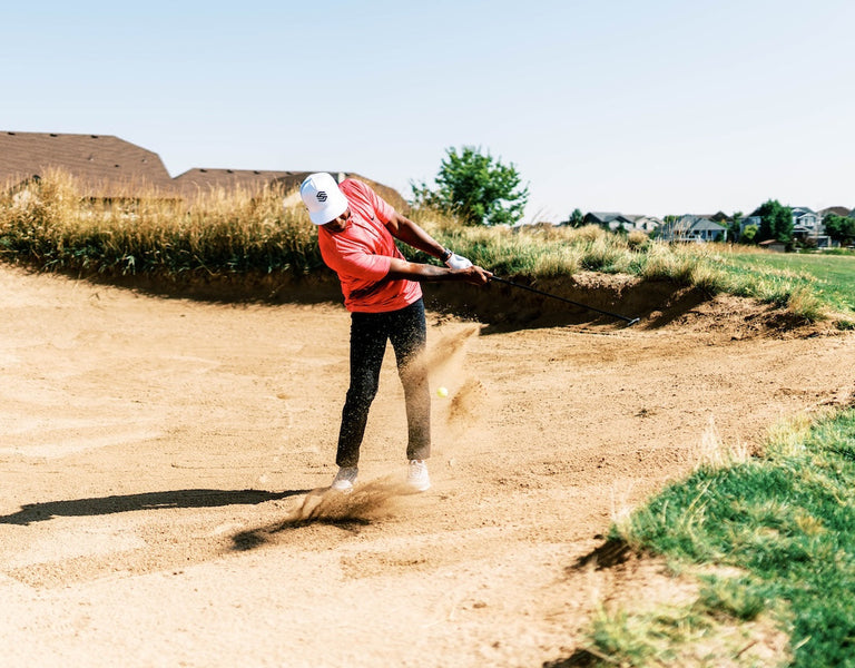 golfer chipping from bunker