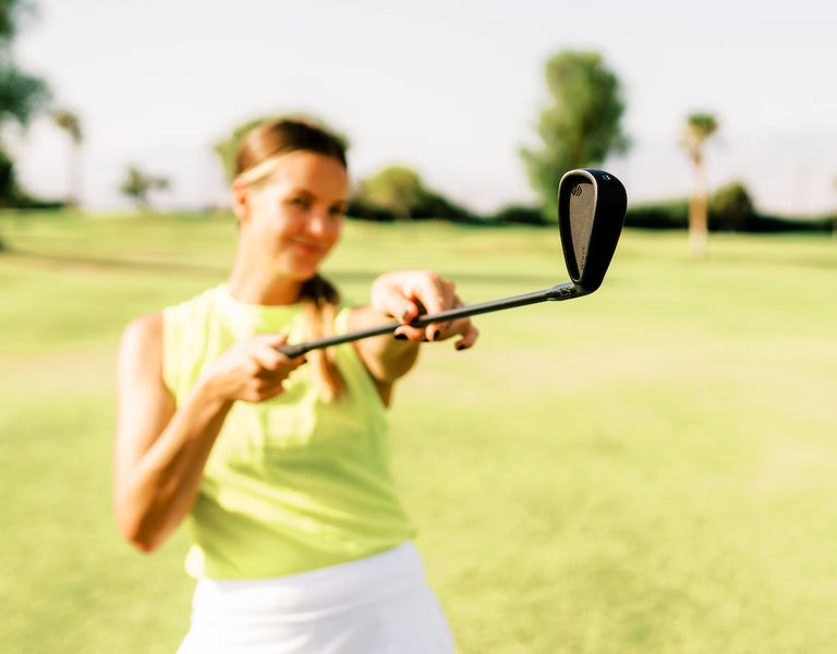 female golfer holding a golf iron