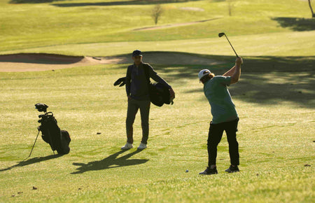 A golfer swinging an iron
