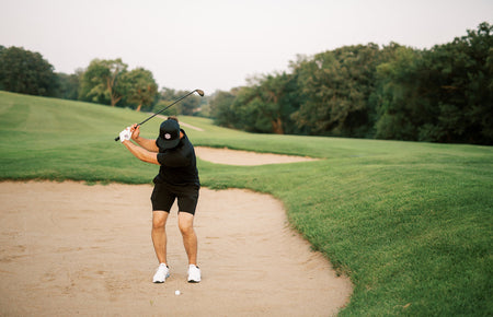 golfer chipping out of sand bunker