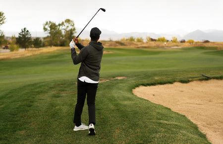 golfer using a wedge next fairway