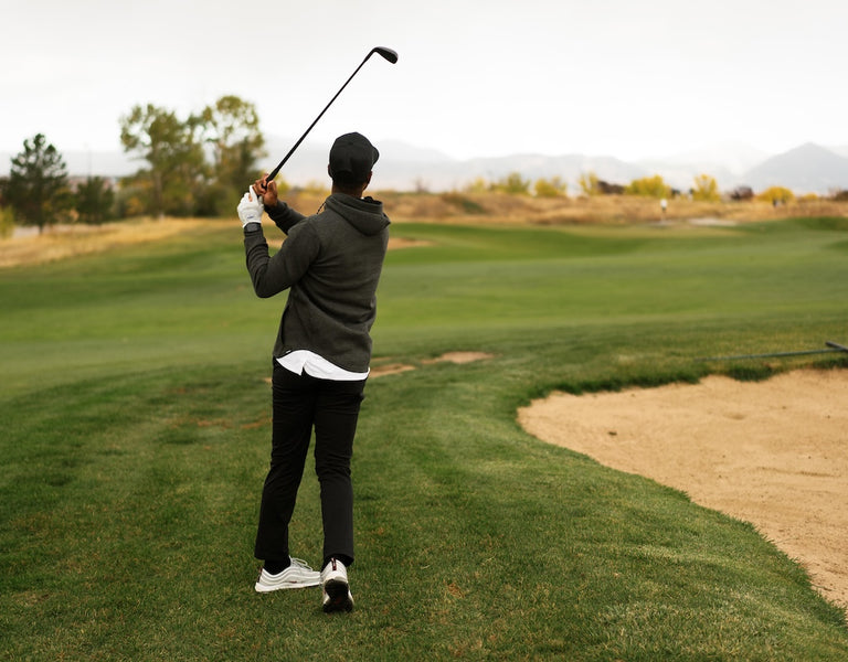 golfer using a wedge next fairway