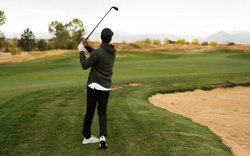 golfer using a wedge next fairway