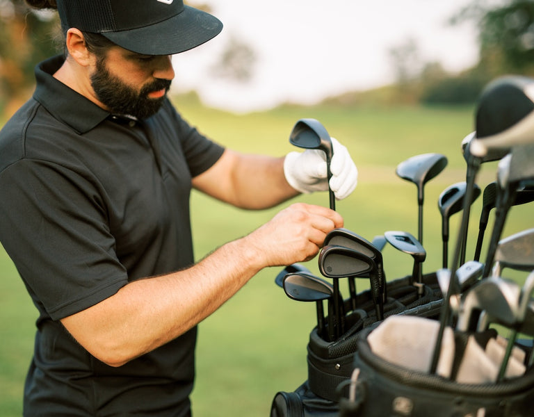 golfer choosing between irons and hybrids in bag