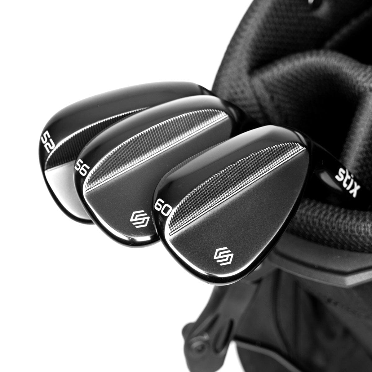 The Stix Compete Wedge Set: matte black 52, 56, and 60 degree wedges fanned out on a green.
