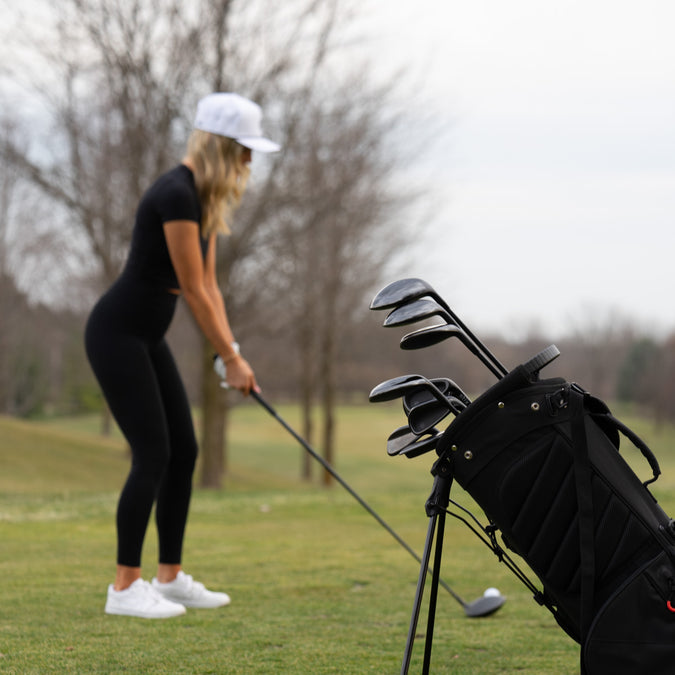 Woman golfing with her set of clubs