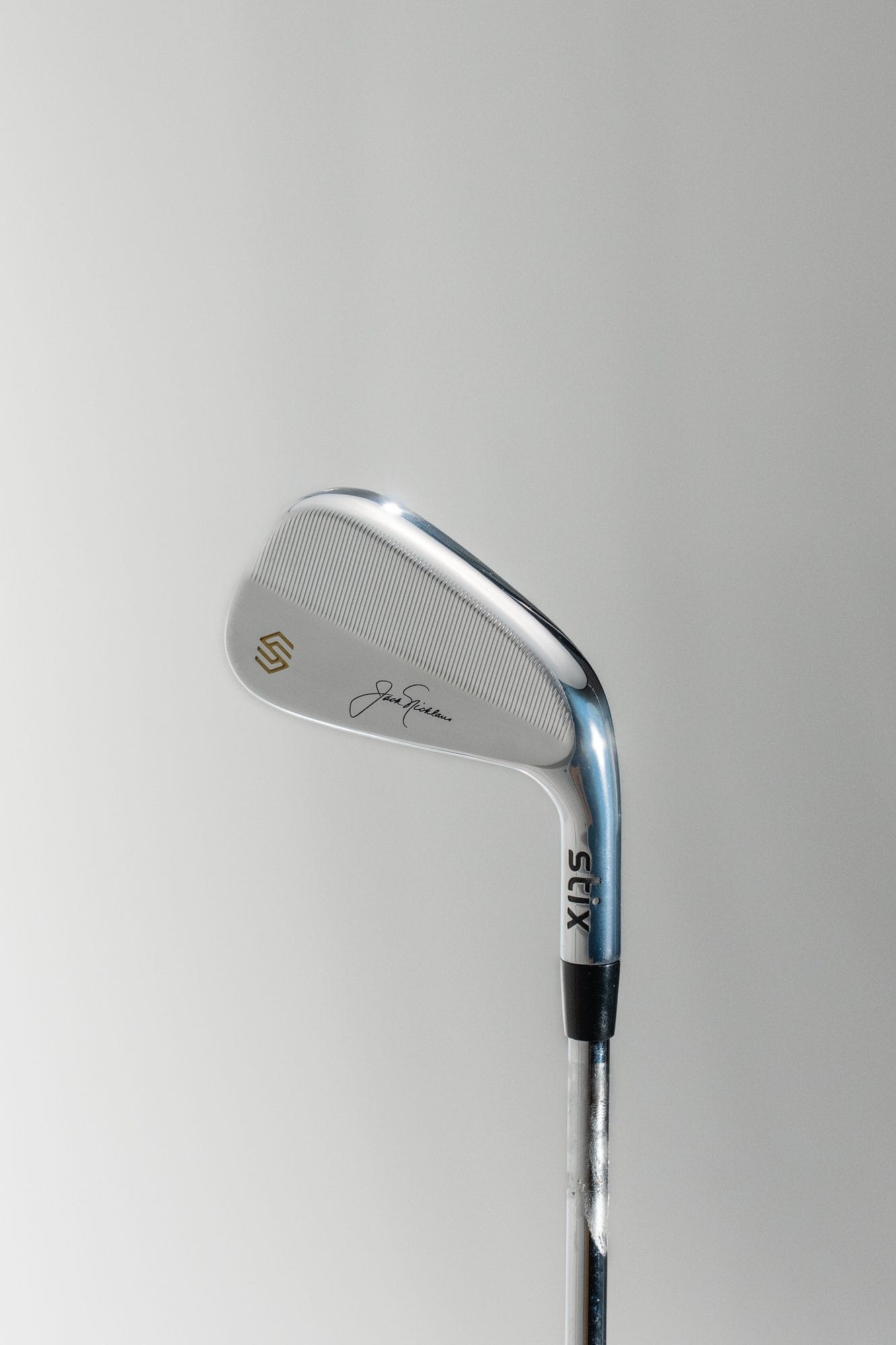 A Stix Nicklaus iron in chrome finish, showing the Jack Nicklaus signature and Stix logo — a contrast to the stealth-black Perform iron.