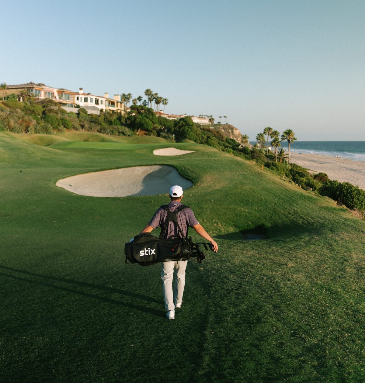 Golfer walking the course carrying a Stix bag